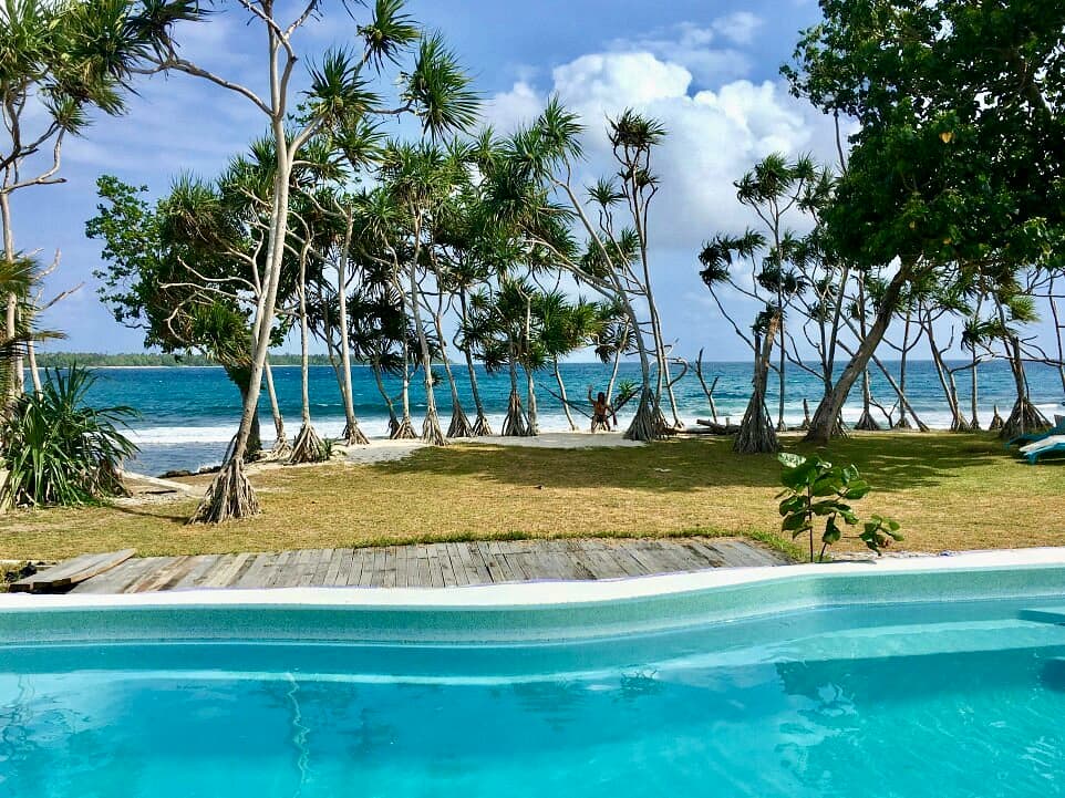 Blue pool with the ocean beyond at Blue Pango Guesthouse